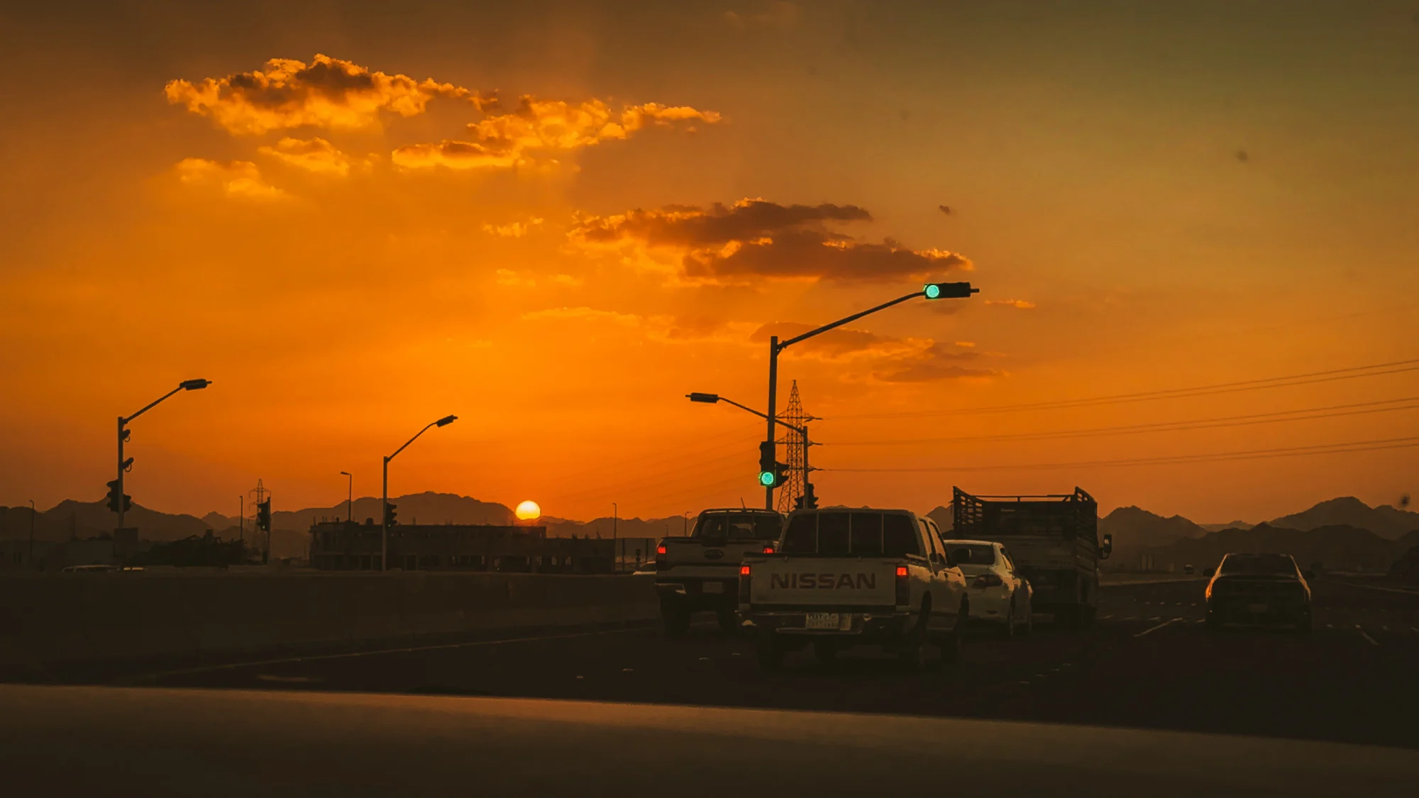 Traffic on a highway under a burning orange sunset
