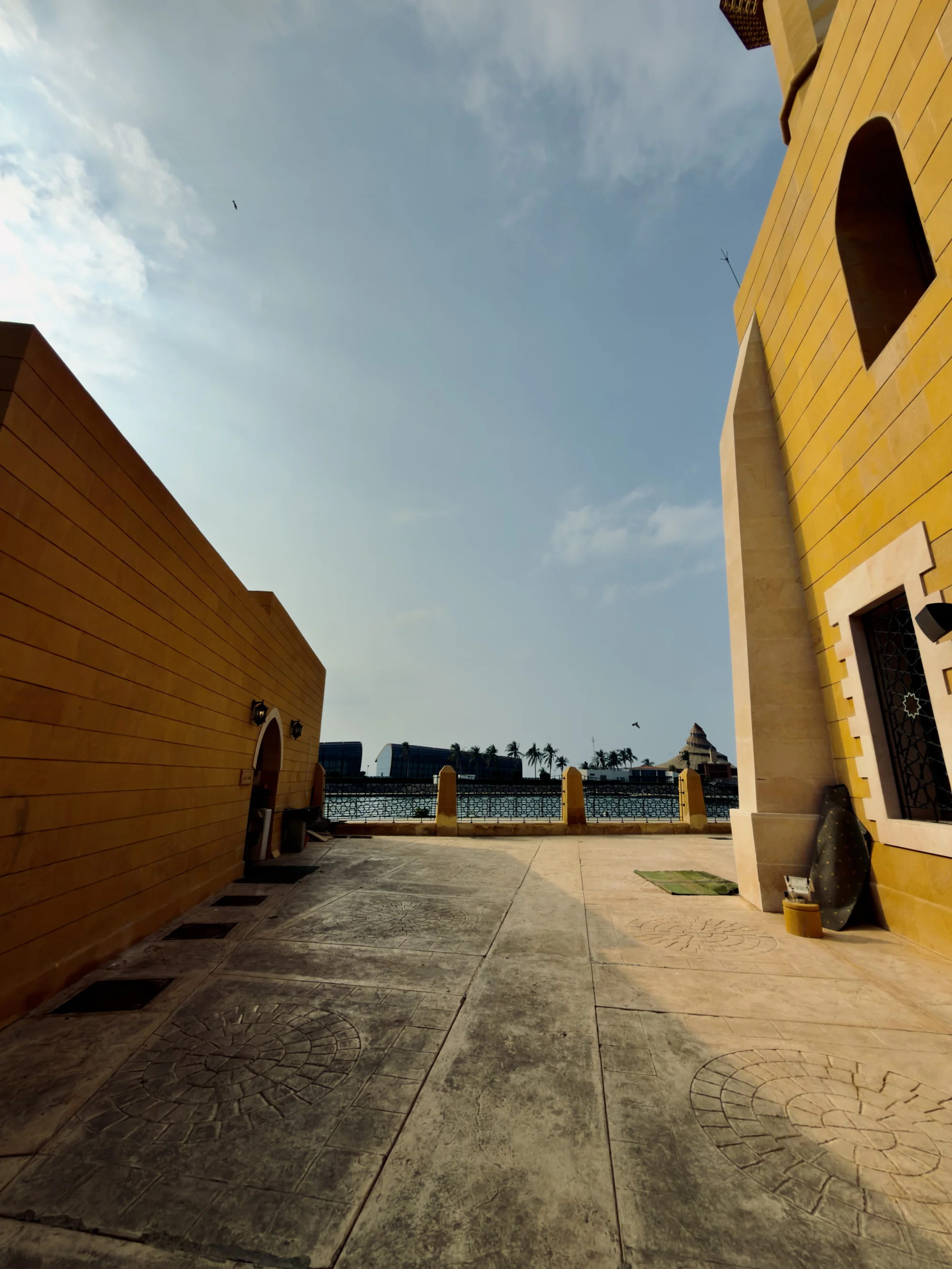 A sunlit courtyard of ochre walls opening onto the sea