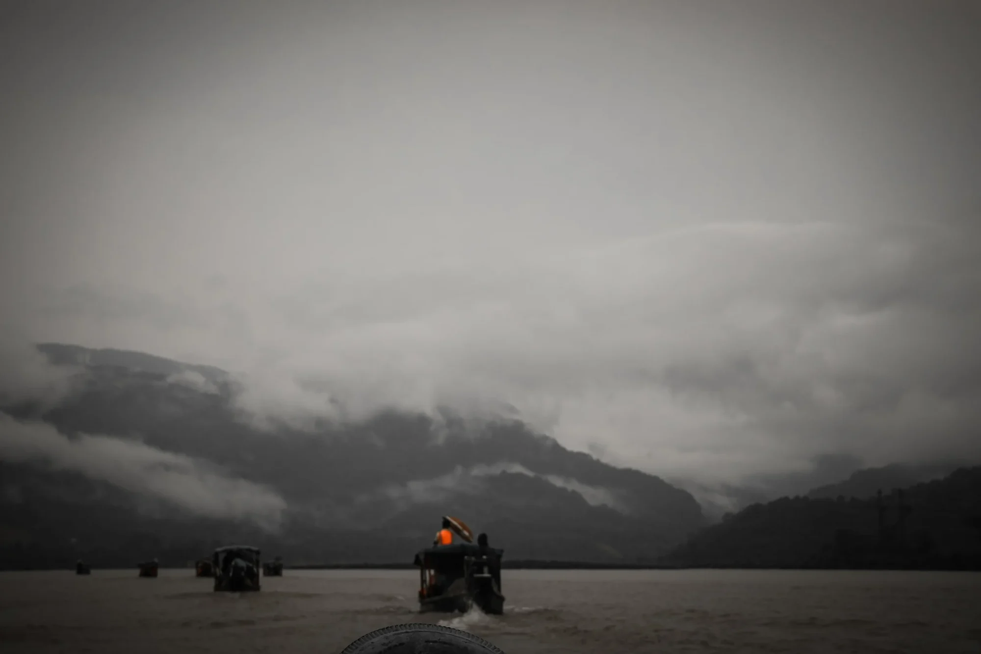 A boat heading toward a hillside buried in cloud