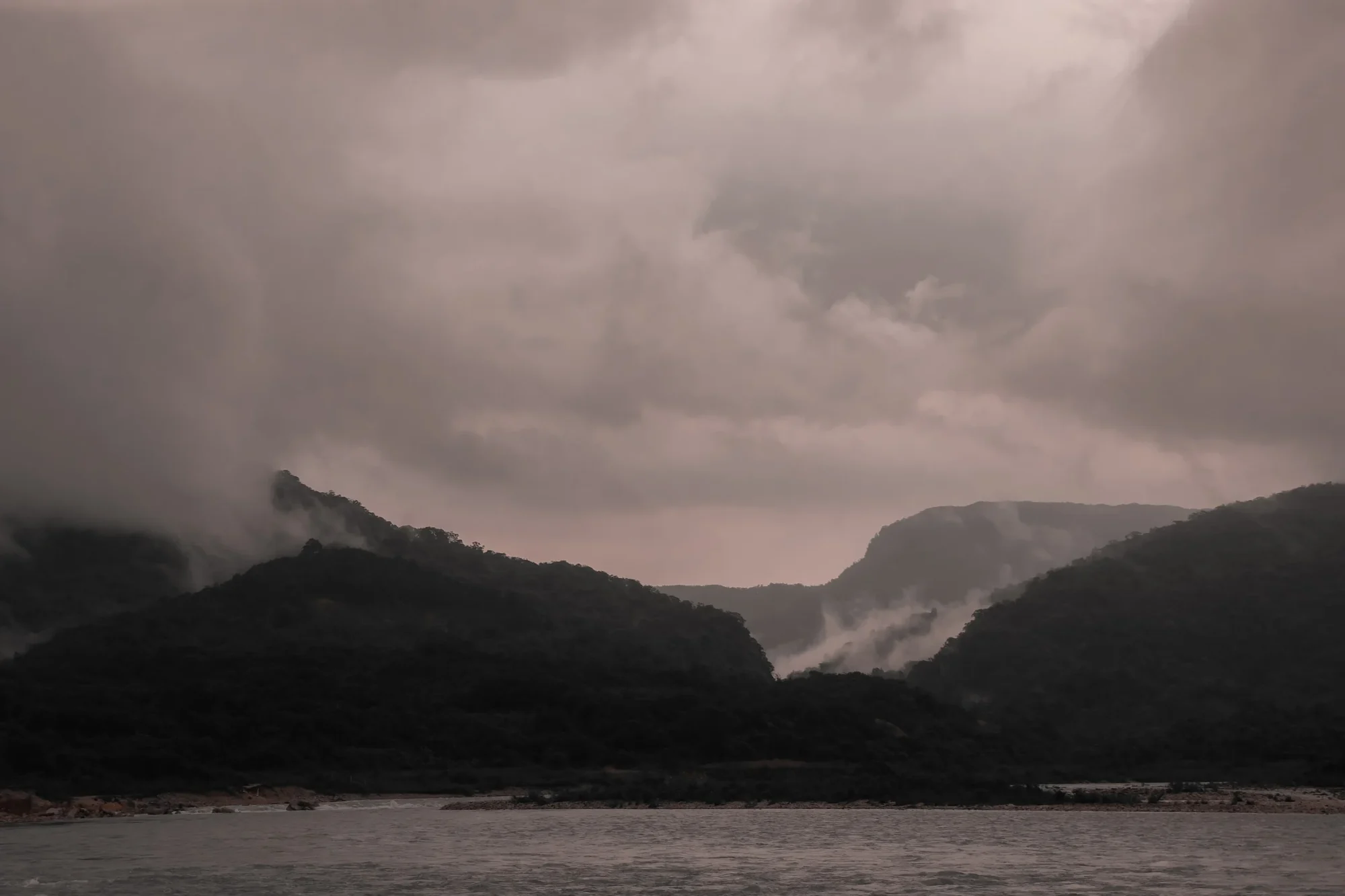 A break between two hills with cloud spilling through