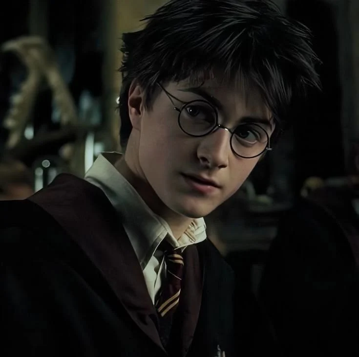 Harry Potter in school robes looking over his shoulder