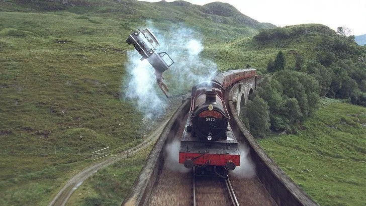A flying Ford Anglia above the Hogwarts Express on a viaduct