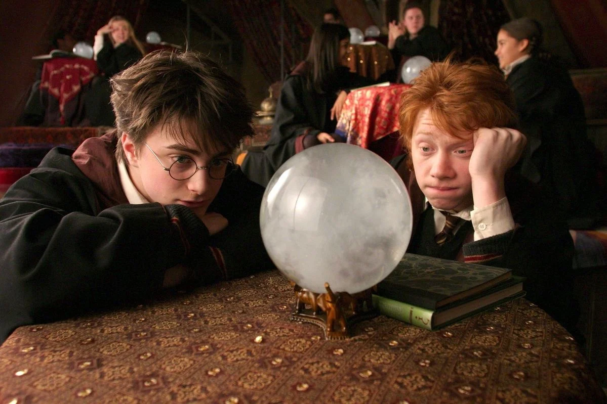 Harry and Ron slumped over a crystal ball in Divination