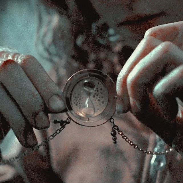 A Time-Turner held open between two hands