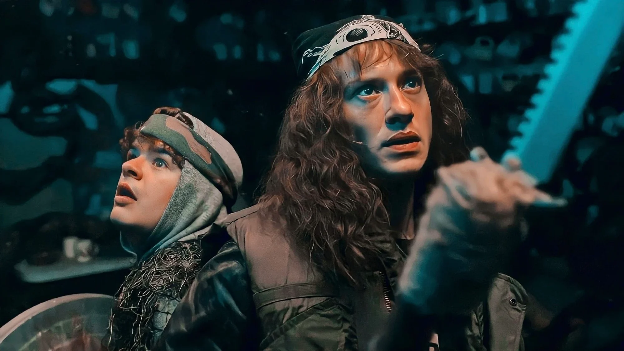 Dustin and Eddie back to back holding weapons in the Upside Down