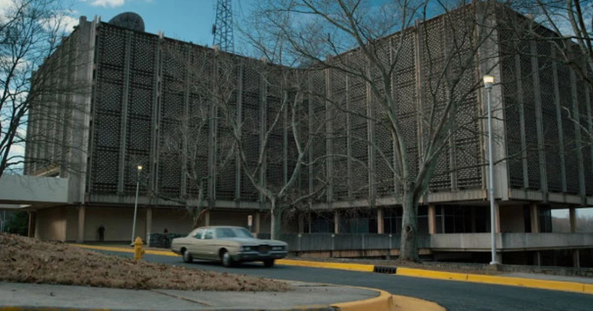 The exterior of Hawkins National Laboratory with a car passing