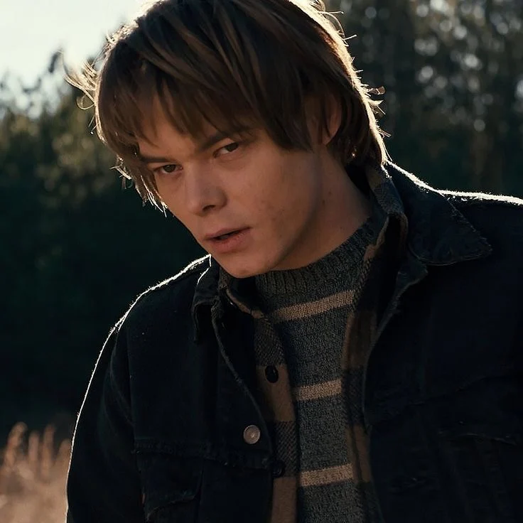Jonathan Byers outdoors in a denim jacket