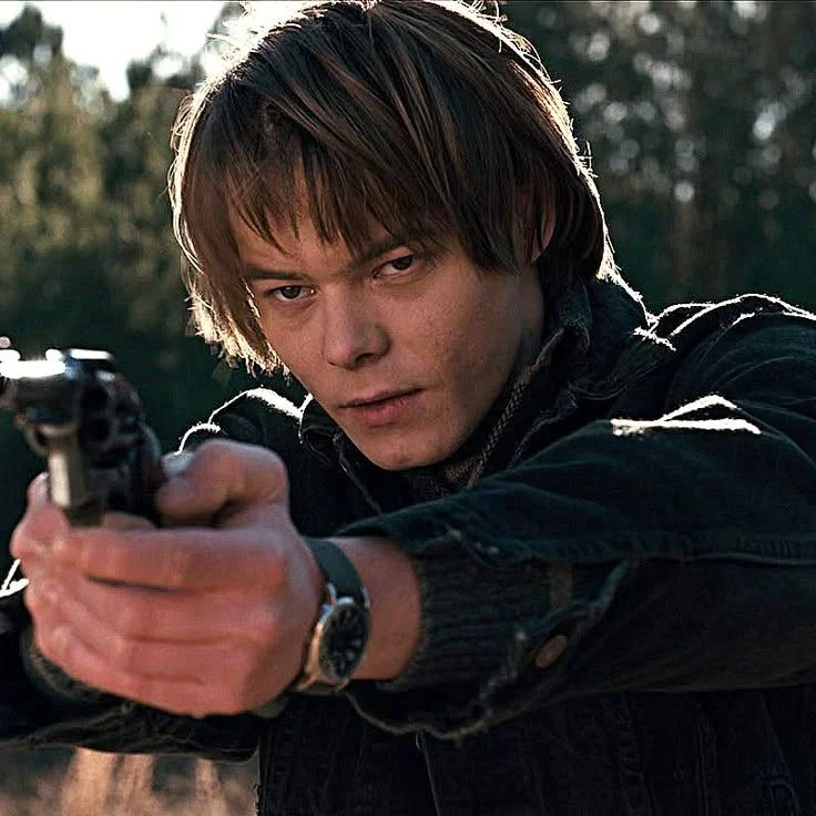 Jonathan Byers aiming a revolver