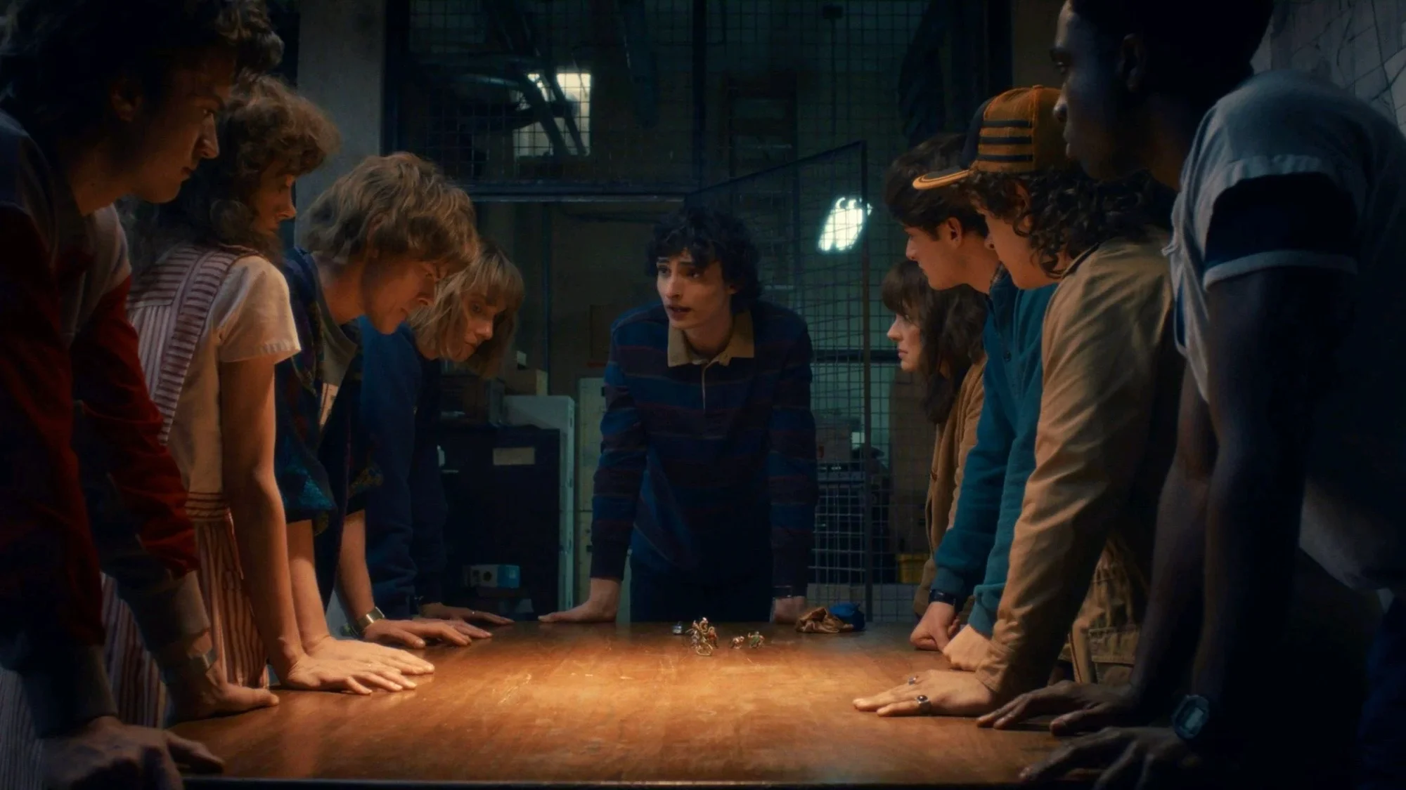 The whole group leaning over a table with figures set out on it