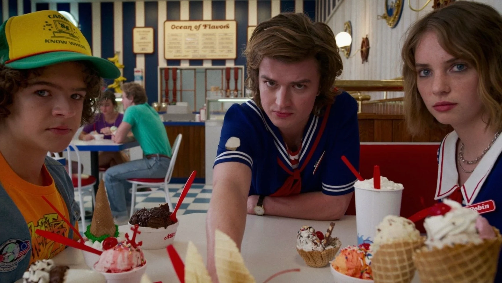 Dustin, Steve and Robin at a table covered in ice cream