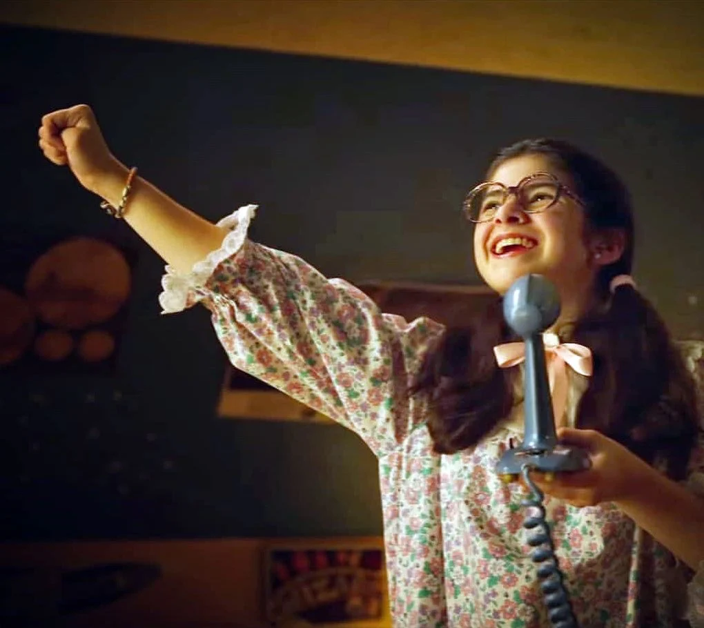 Suzie in a nightgown, cheering into a telephone receiver