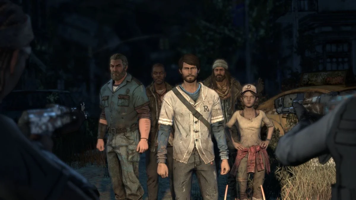 The group standing together at night with guns pointed at them from both sides