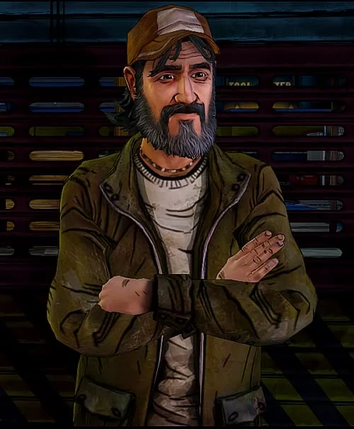 Kenny standing with his arms crossed, half smiling